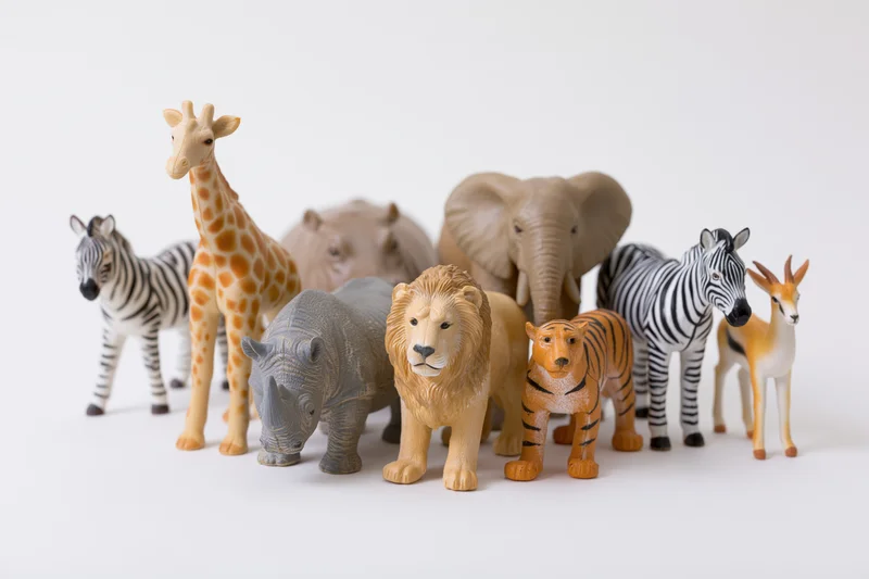 Plastic safari animal figurines arranged in a group on a white surface