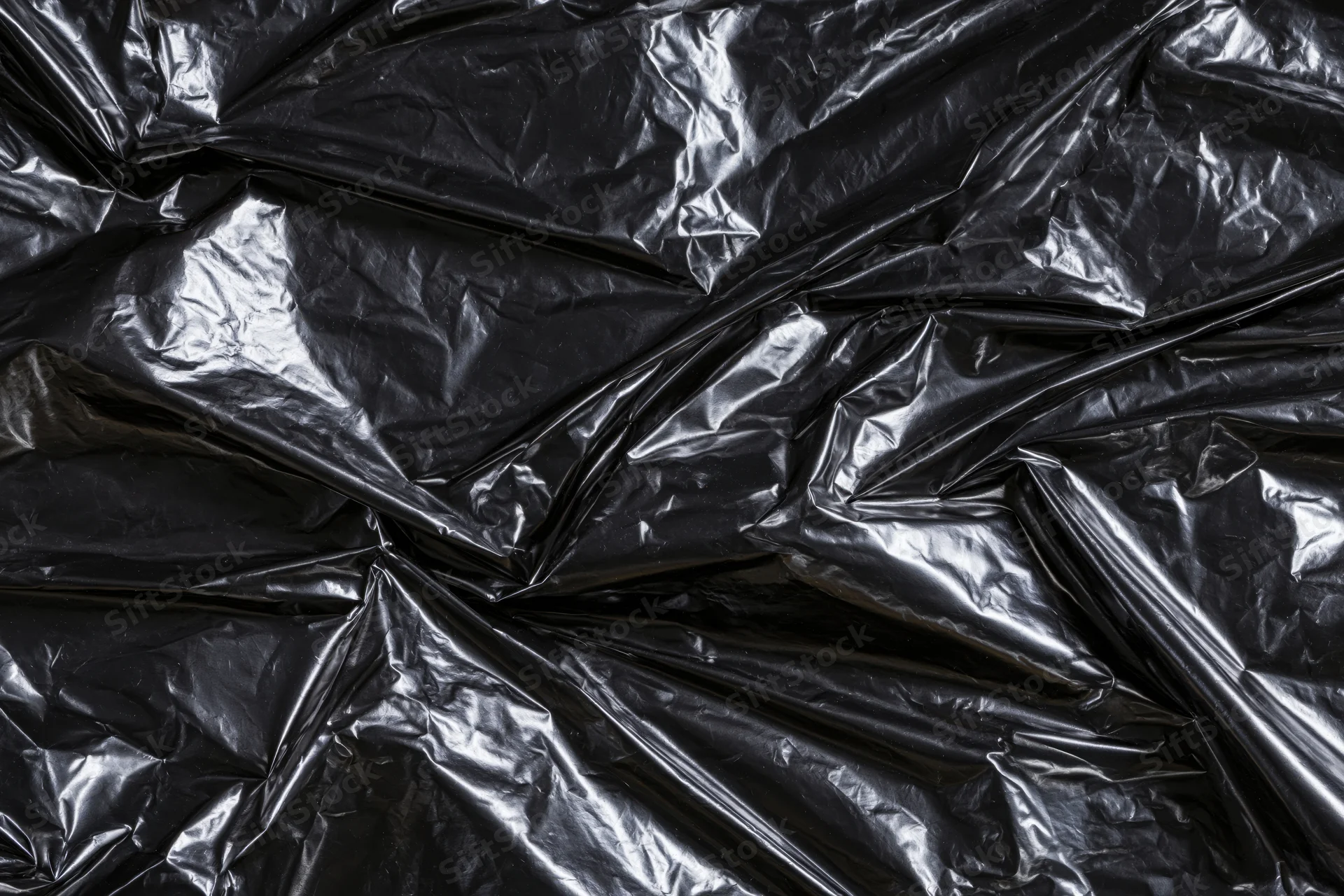 Crumpled black plastic sheeting filling the frame as a textured surface