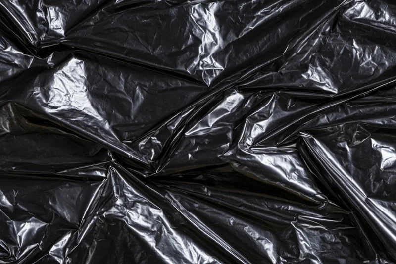 Crumpled black plastic sheeting filling the frame as a textured surface