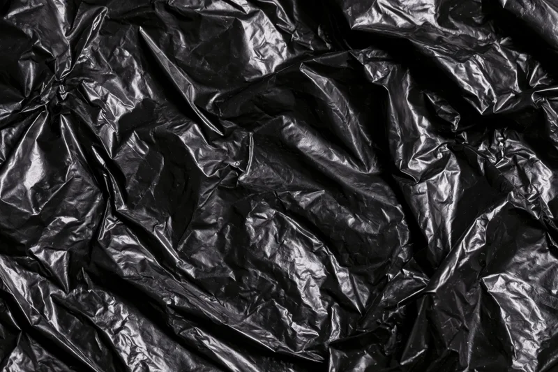 Crumpled black plastic sheeting filling the frame as a textured surface