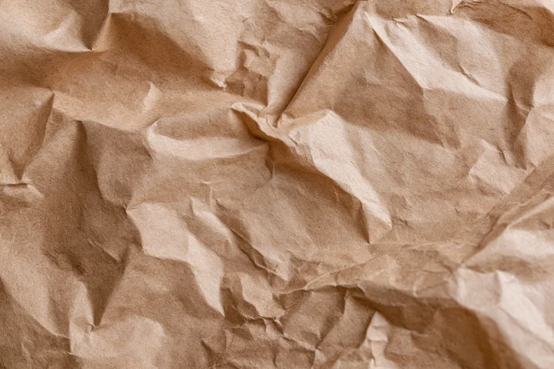 Crumpled kraft brown wrapping paper filling the frame