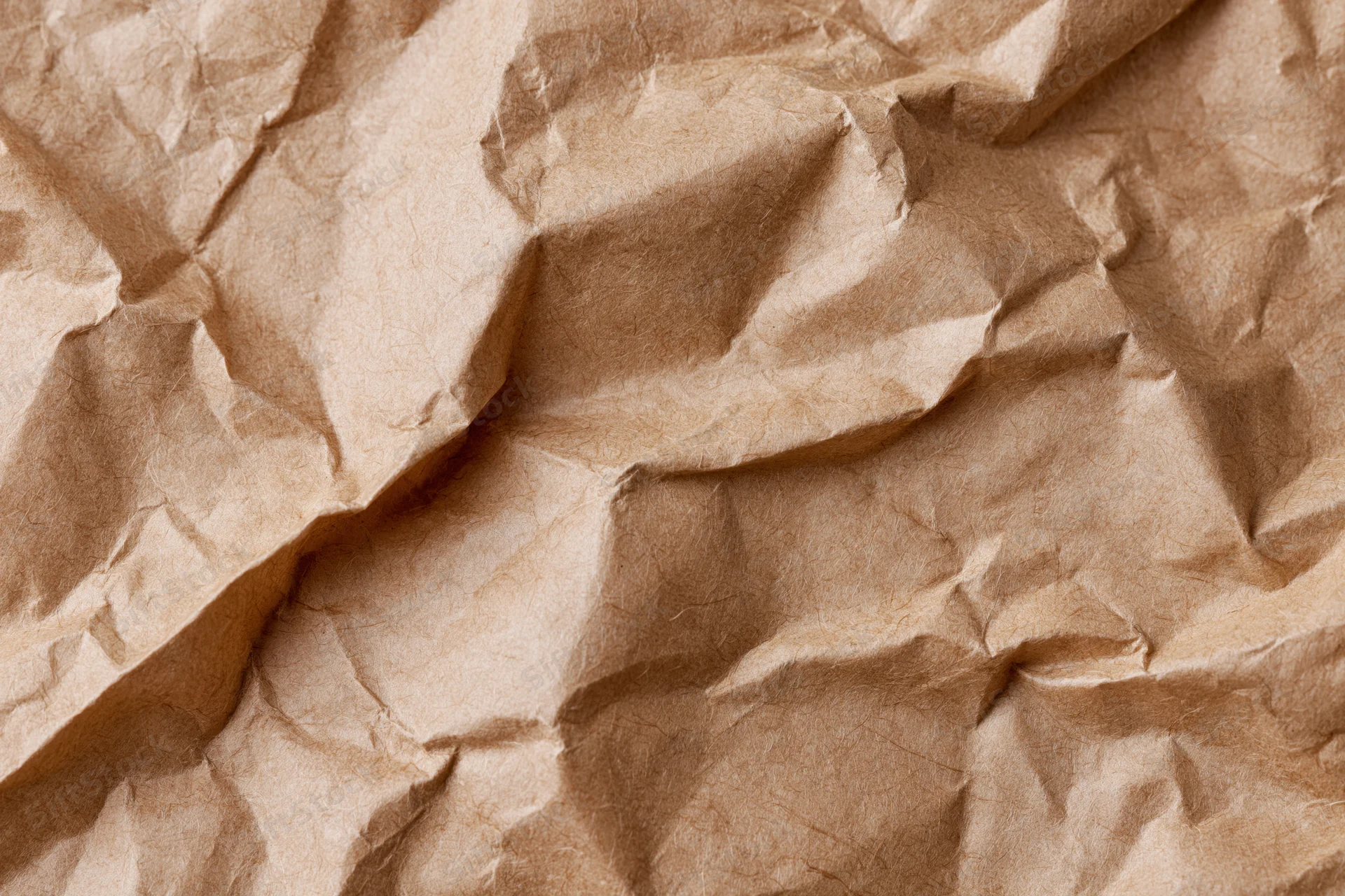 Crumpled kraft brown wrapping paper filling the frame