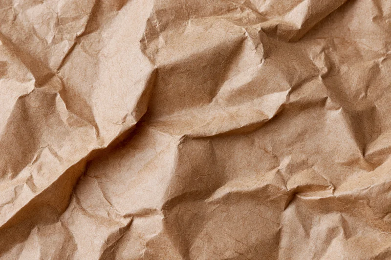 Crumpled kraft brown wrapping paper filling the frame