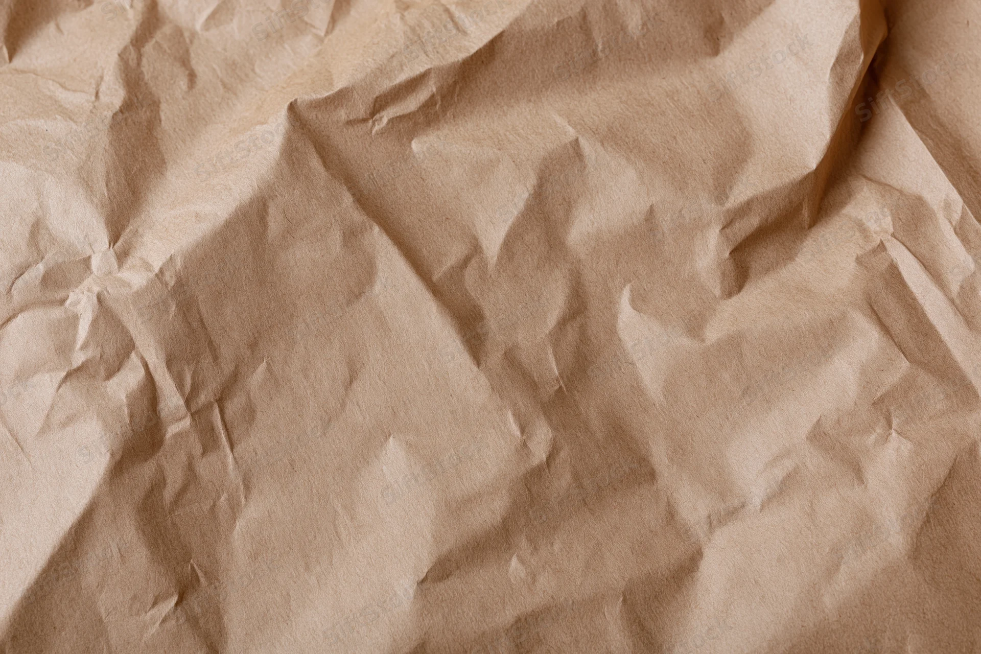 Crumpled kraft brown wrapping paper filling the frame