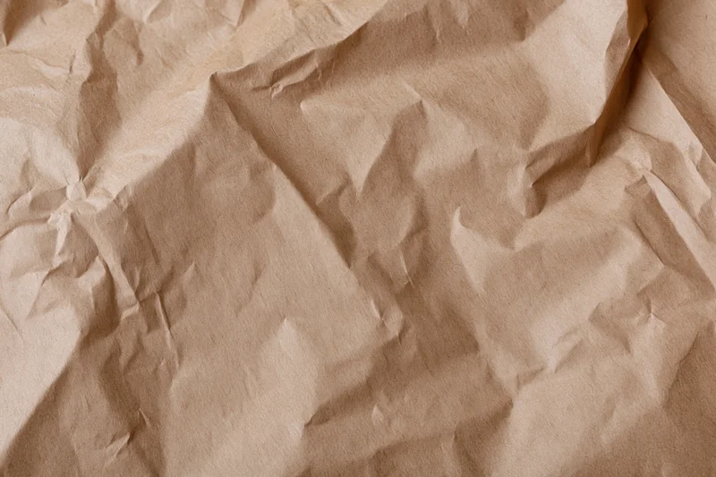 Crumpled kraft brown wrapping paper filling the frame