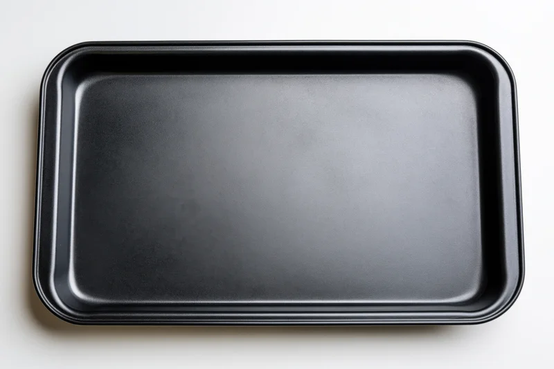Empty black nonstick baking tray viewed from above on white surface