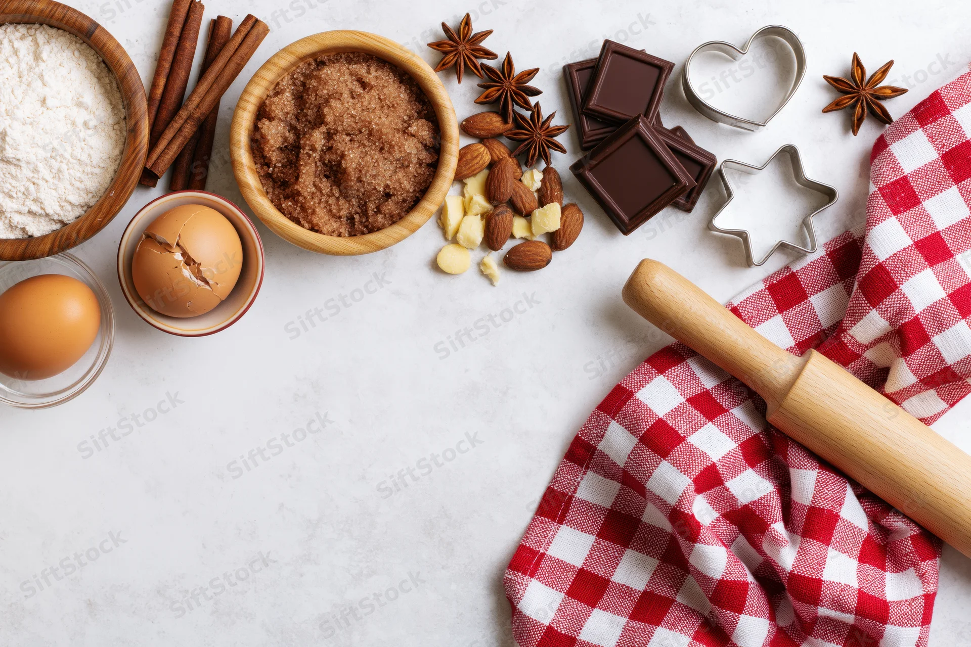 Baking ingredients arranged along the top edge of a marble countertop with copyspace below