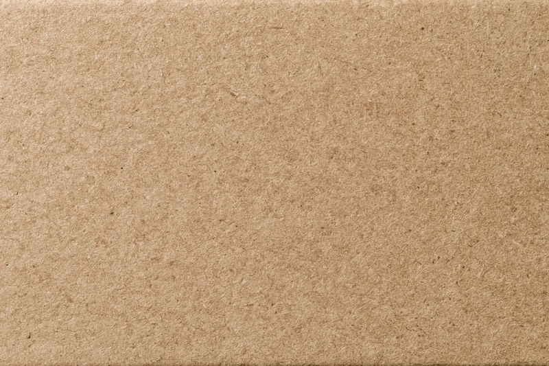 Close-up of a plain kraft brown cardboard sheet surface
