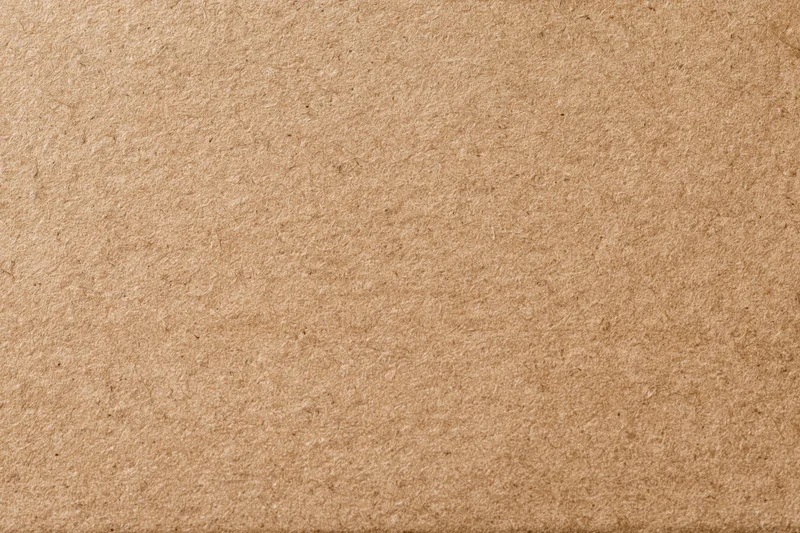 Close-up of a plain kraft brown cardboard sheet surface