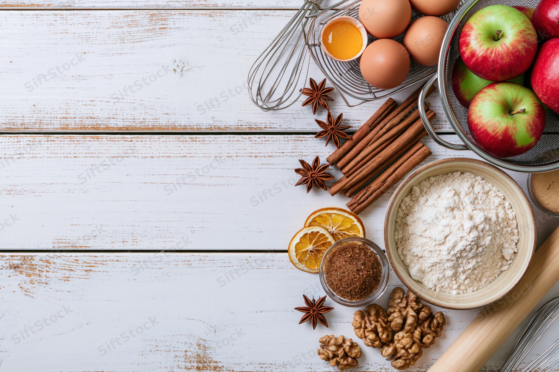 Autumn baking ingredients arranged on a white wooden tabletop with copyspace