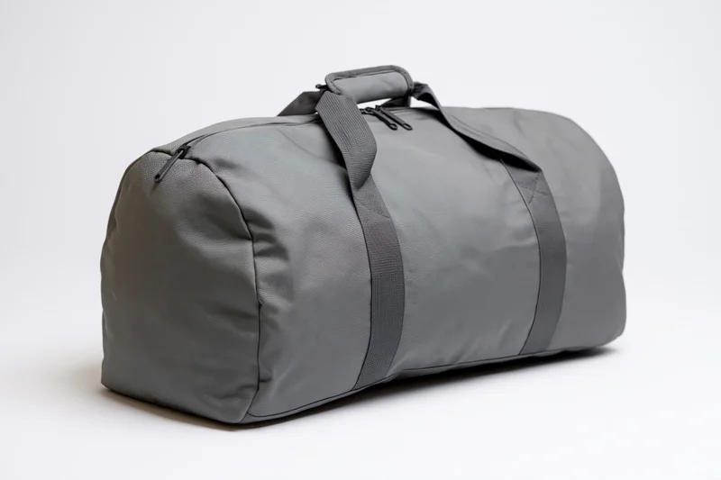 Gray nylon duffel bag resting upright on white background