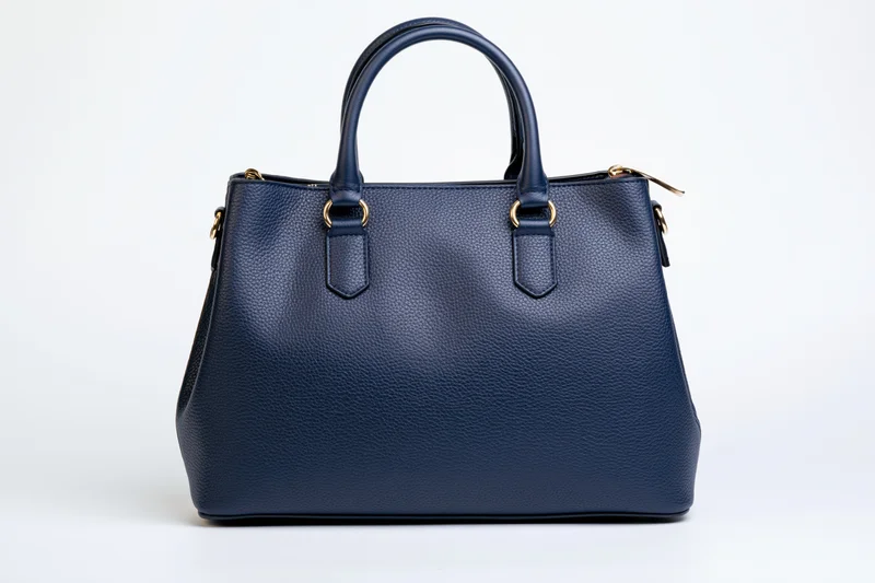 Navy blue pebbled leather tote handbag photographed straight-on against white background