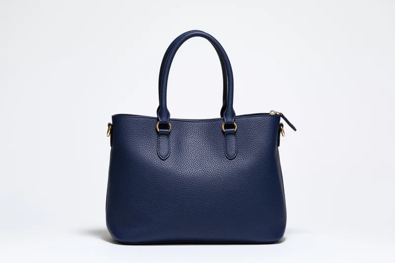Navy blue pebbled leather tote handbag photographed straight-on against white background