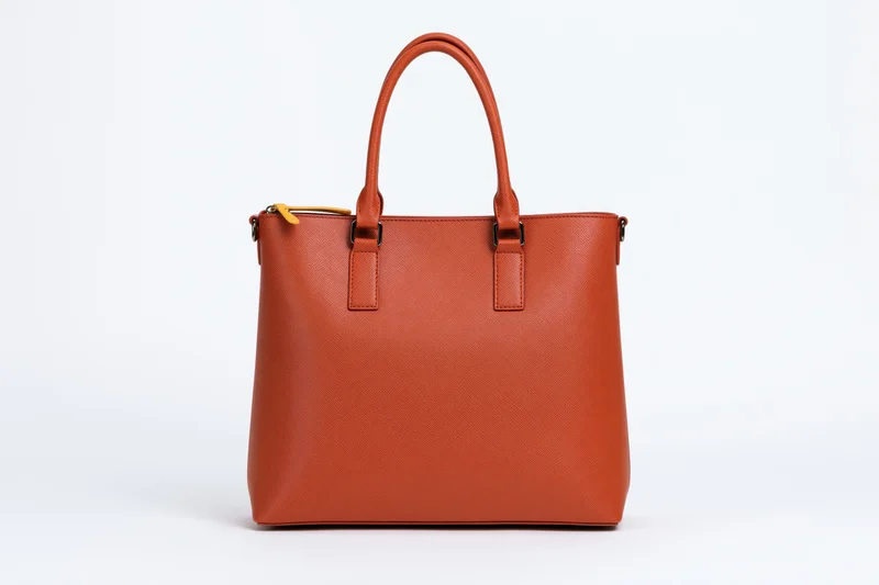 Orange saffiano leather tote bag standing upright centered on white background