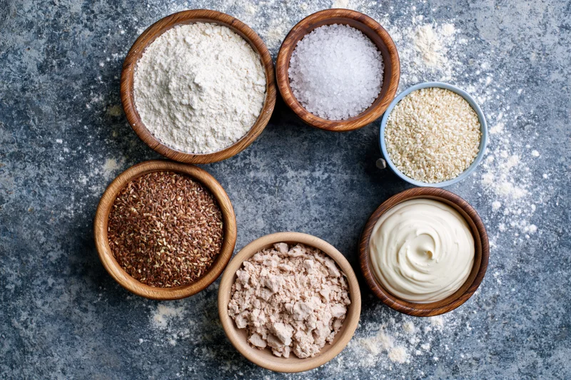 Baking ingredients arranged in a circular flat lay on a textured gray surface