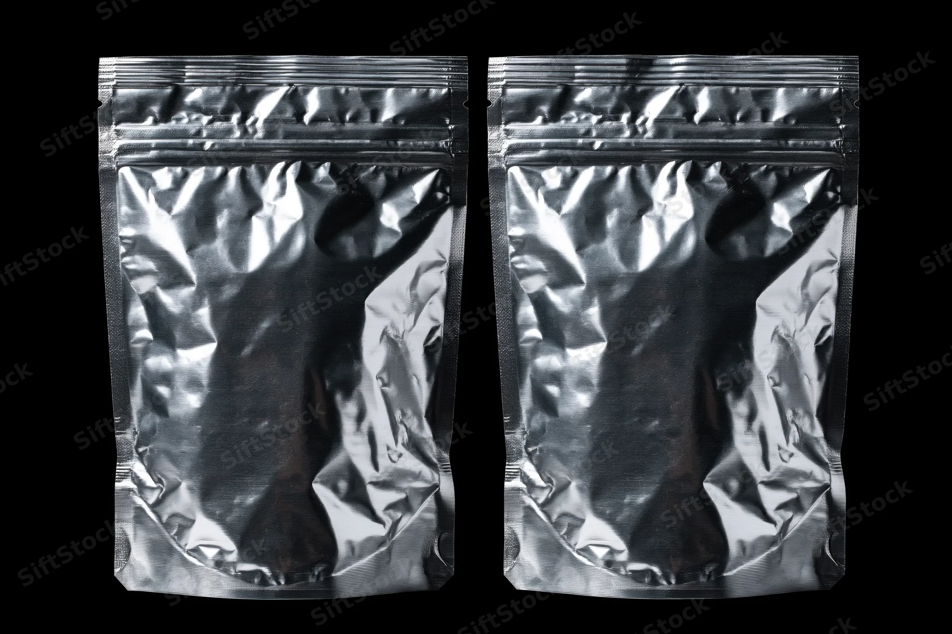 Two sealed metallic foil snack pouches side by side on black background