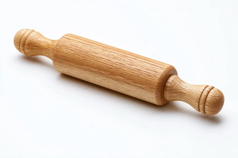 Wooden rolling pin with turned handles resting on white surface