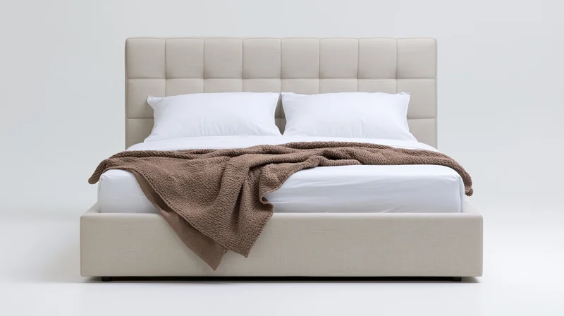 Modern upholstered queen bed with tufted headboard and white bedding on plain background