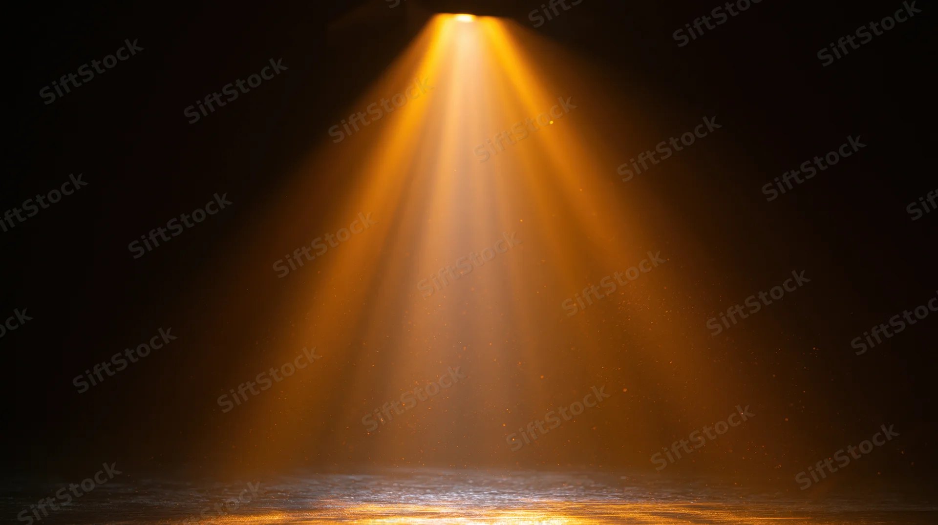 Golden spotlight beam shining downward on dark stage floor