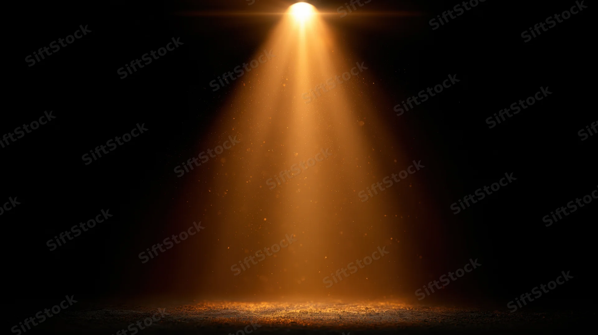Golden spotlight beam shining downward on dark stage floor
