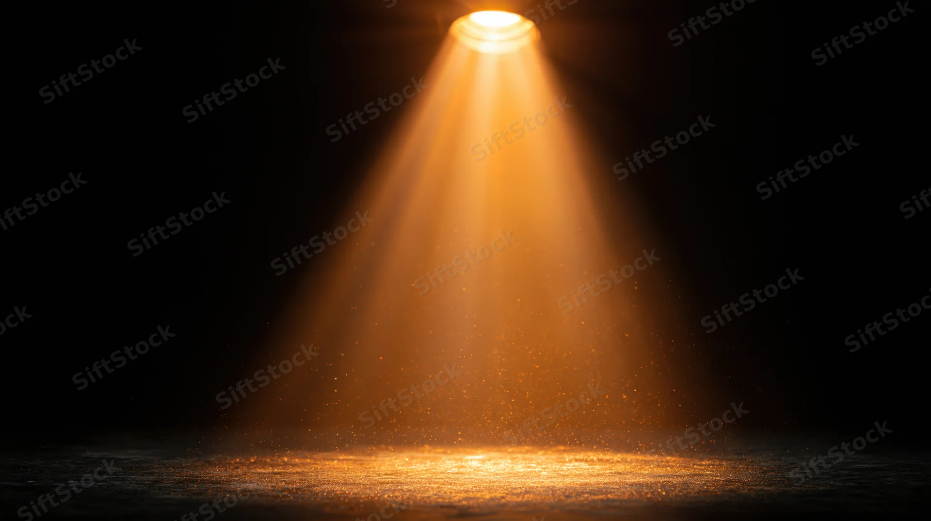 Golden spotlight beam shining downward on dark stage floor