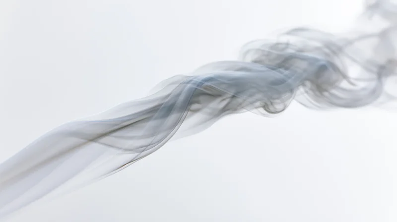 A wisp of gray smoke drifting diagonally across a pure white background