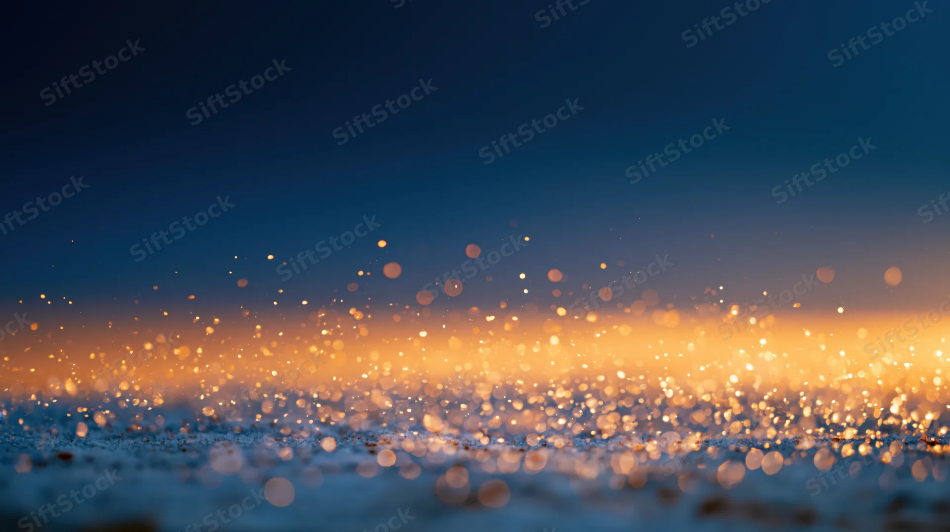 Abstract bokeh background with floating golden light particles at dusk