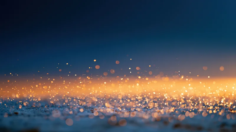 Abstract bokeh background with floating golden light particles at dusk