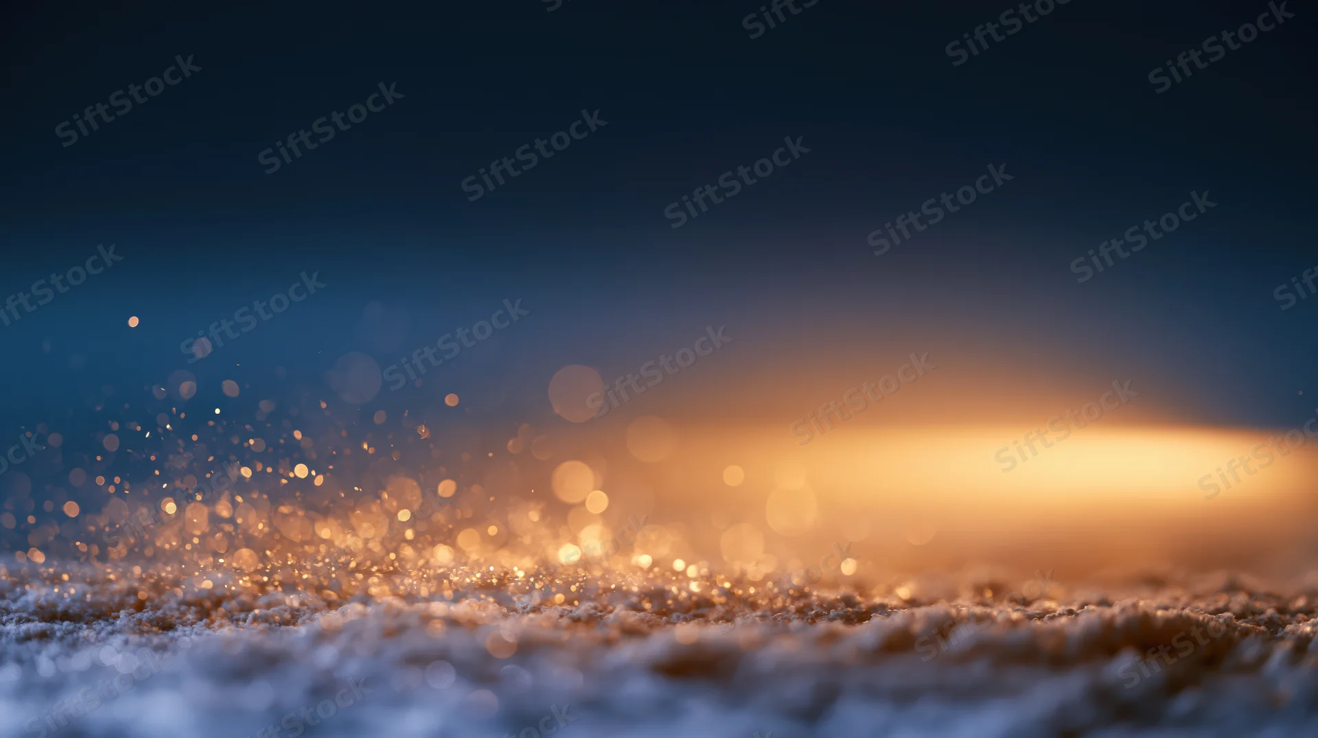 Golden light particles floating over textured surface against dark blue gradient background