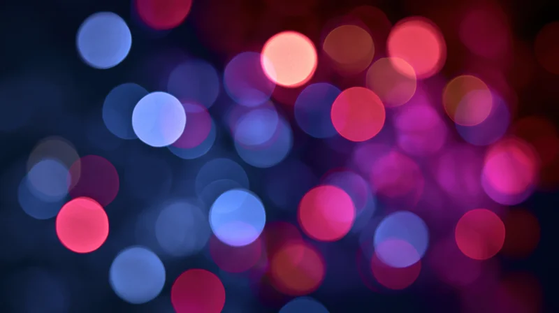 Abstract bokeh background with blurred colorful light orbs in dark setting