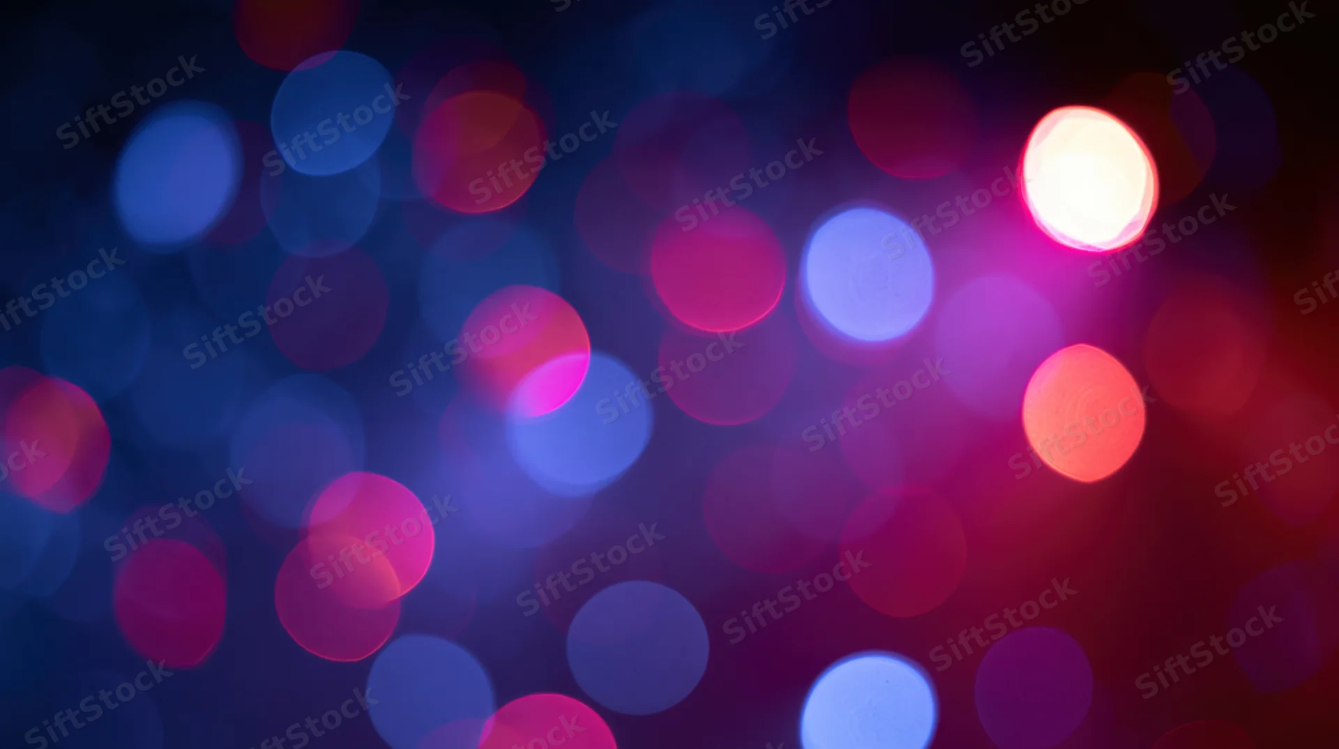 Abstract bokeh background of out-of-focus colored light orbs in pink, purple, and blue hues