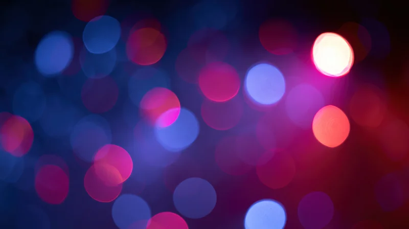 Abstract bokeh background of out-of-focus colored light orbs in pink, purple, and blue hues