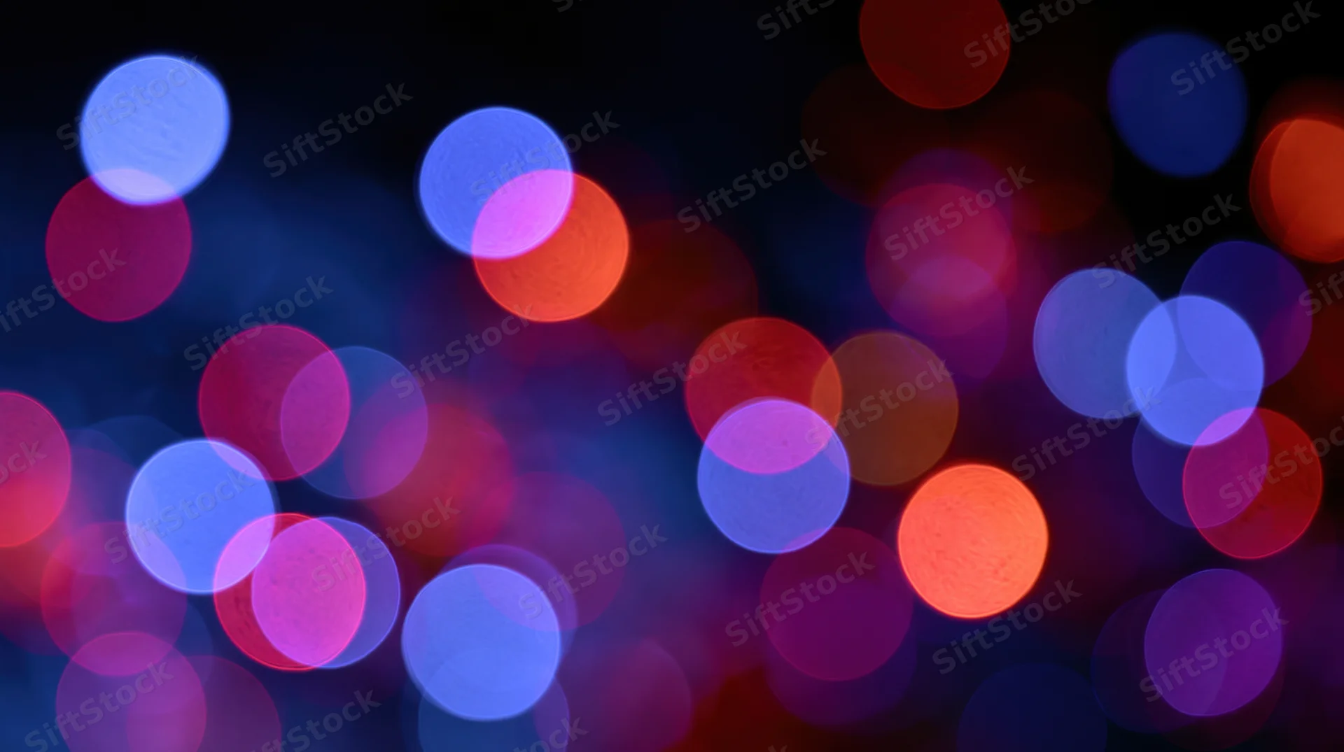 Abstract bokeh background with out-of-focus colorful light orbs in dark setting