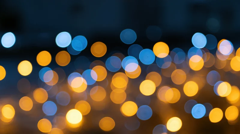 Blurred circular lights in blue and yellow tones across a dark background