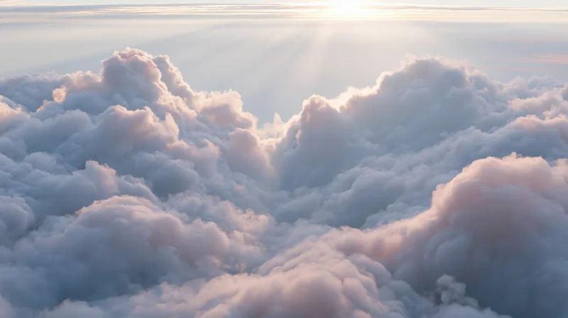 Aerial view of fluffy clouds above horizon at sunrise
