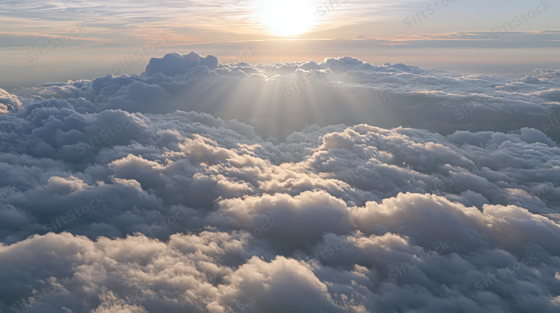 Aerial view of cloudscape with sun rising above horizon