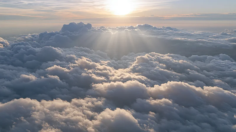 Aerial view of cloudscape with sun rising above horizon