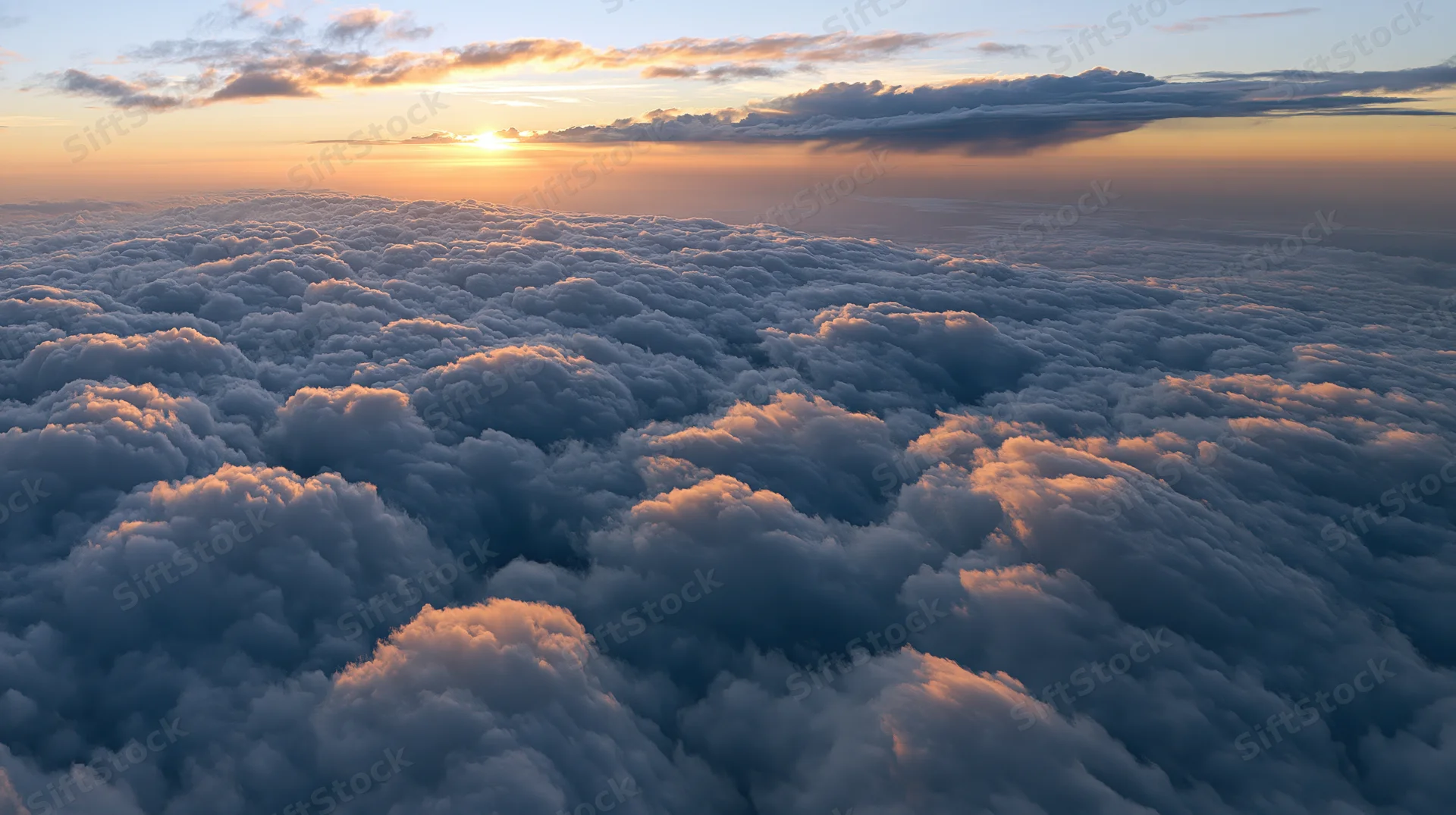 Aerial view of dense cumulus clouds at sunset above the horizon