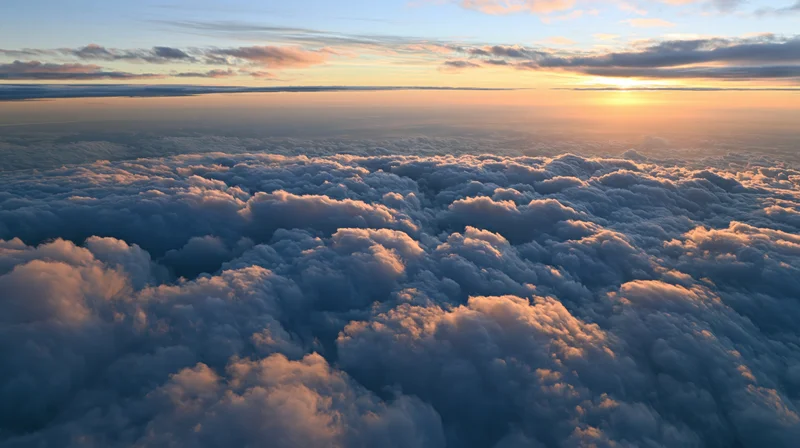 Aerial view above a vast sea of dense cumulus clouds at sunset
