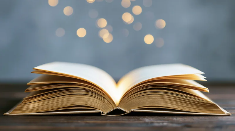 Open hardcover book resting on dark wooden table with glowing bokeh lights in background