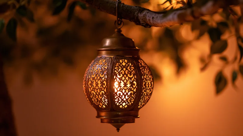 Ornate brass arabic lantern hanging from a tree branch glowing warmly at night