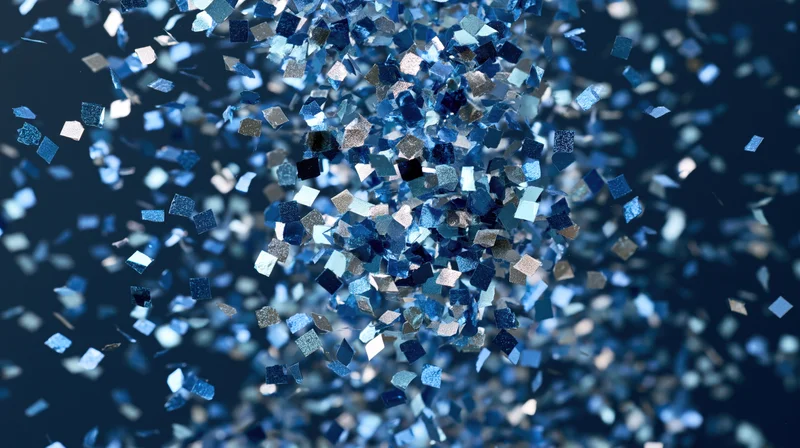 Blue and silver metallic confetti pieces falling in mid-air against a dark background