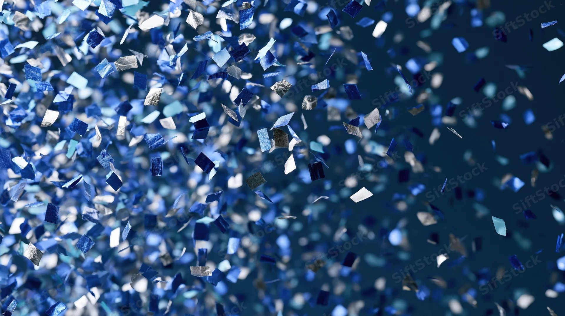 Blue and silver metallic confetti pieces falling against a dark background