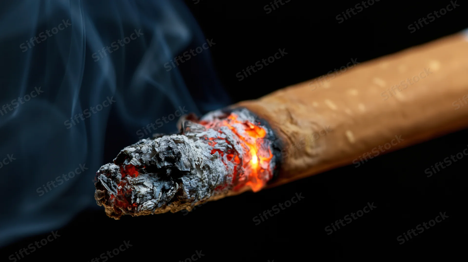 Lit cigarette tip with glowing ember and rising smoke against black background