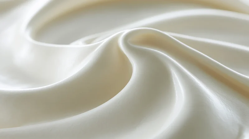 Close-up of smooth white cream surface with swirling texture