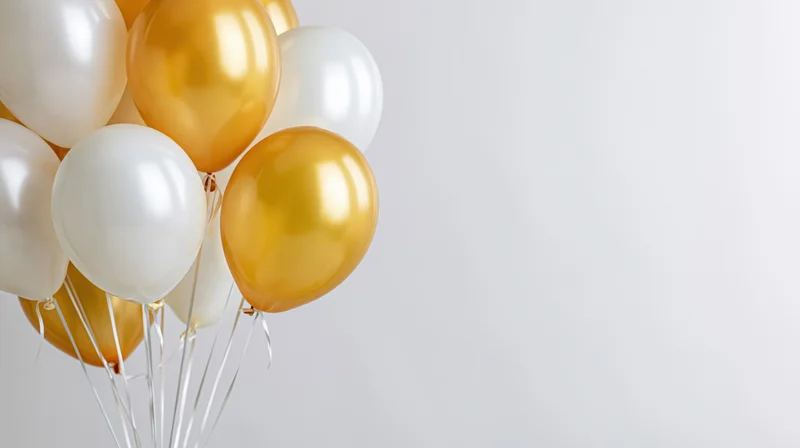 Cluster of white and gold helium balloons floating against a plain white background with copyspace