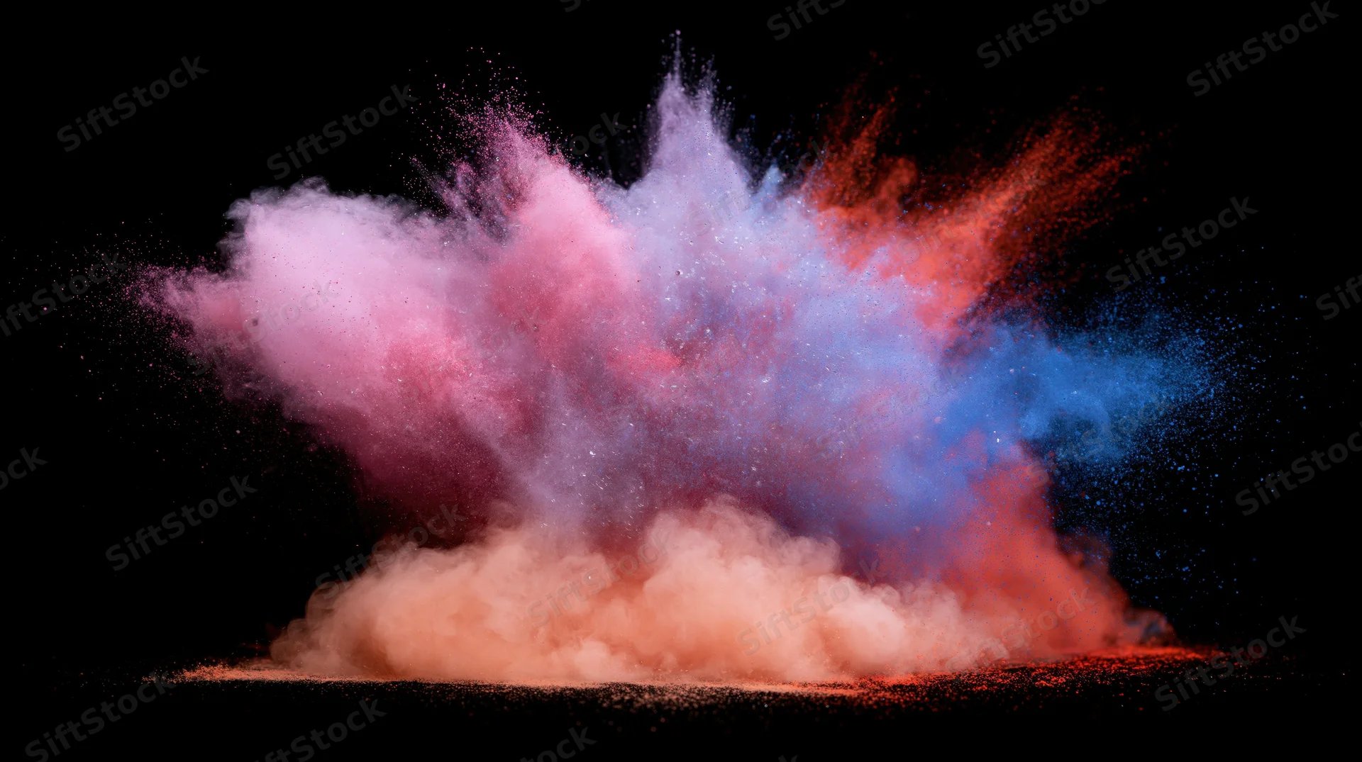 Colored powder exploding in mid-air against a black background