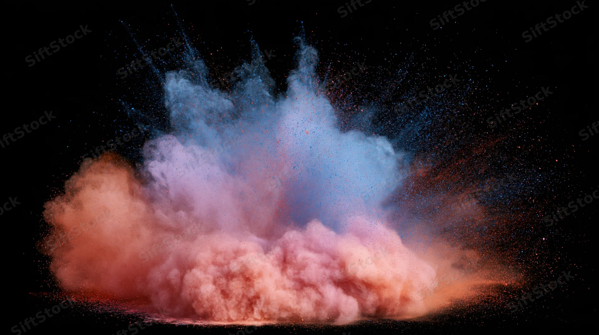 Colored powder exploding in mid-air against a black background