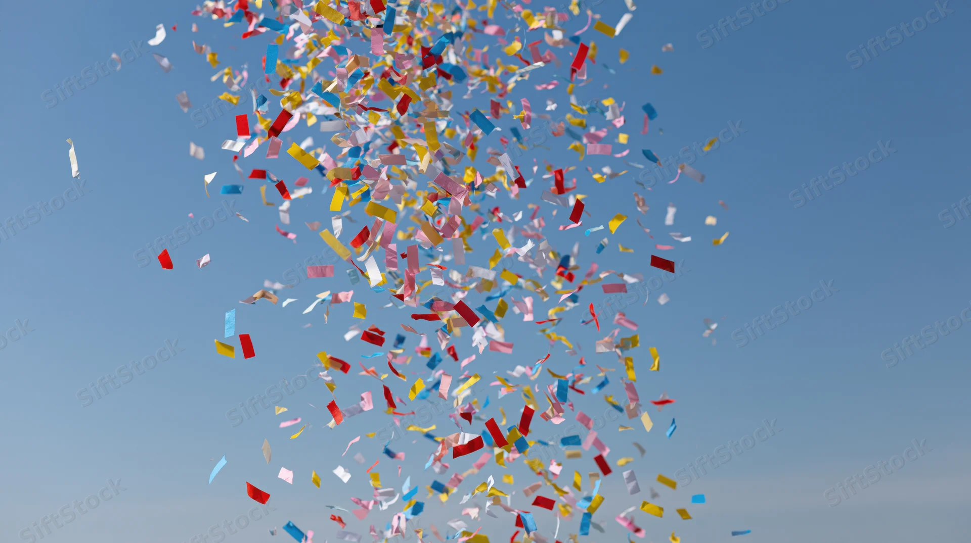 Colorful confetti and paper streamers exploding upward into the sky