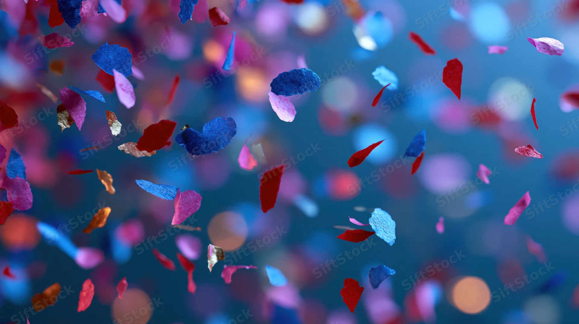Colorful paper confetti pieces falling midair against a blurred bokeh background